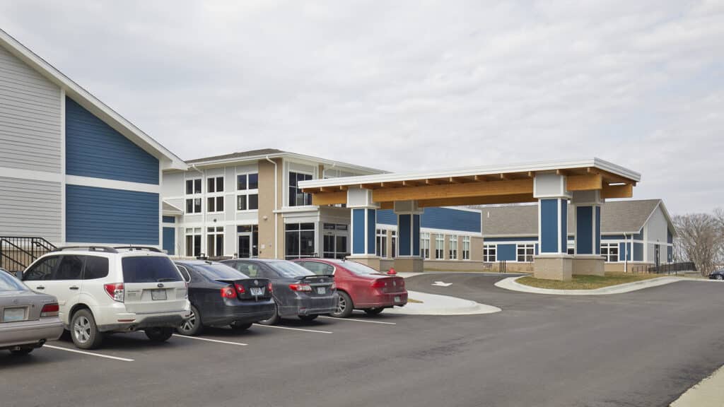 Exterior view of a senior living facility with parking area