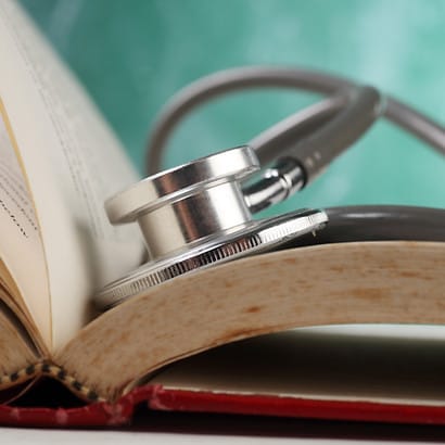 A stethoscope lying on an open book
