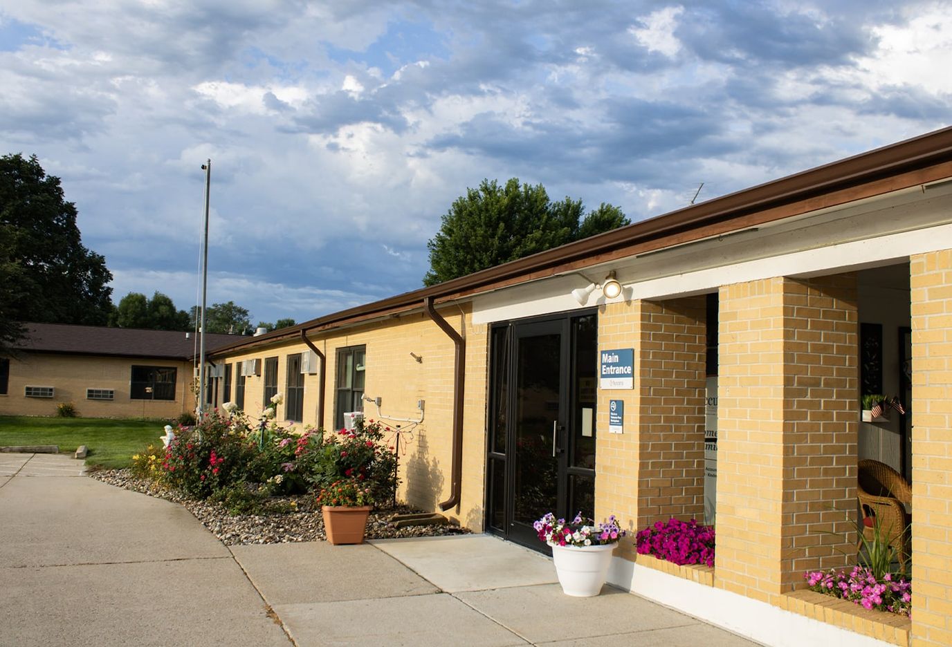 Front entrance of a nursing home facility with flower beds