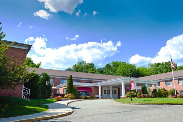 Exterior view of a senior living facility with cloudy sky