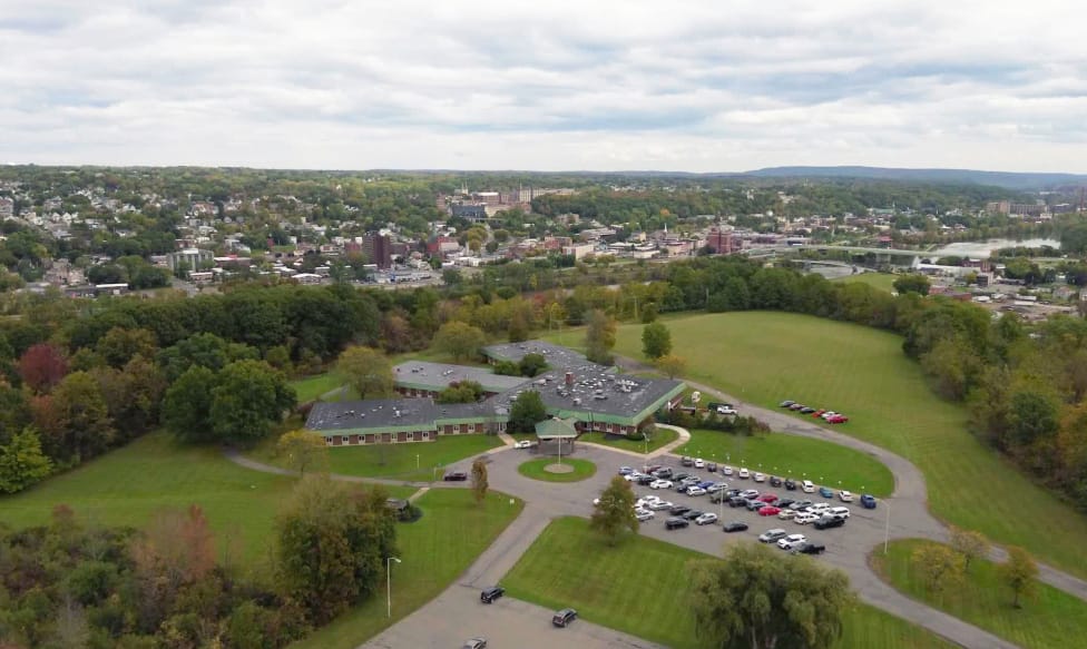 Aerial view of a senior living facility surrounded by green fields