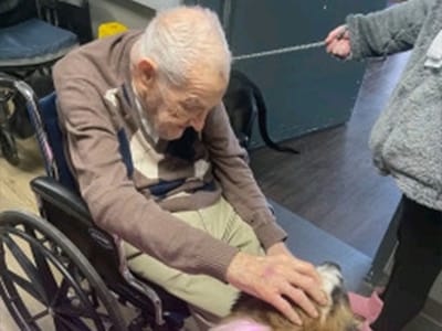 An elderly resident interacting with a dog