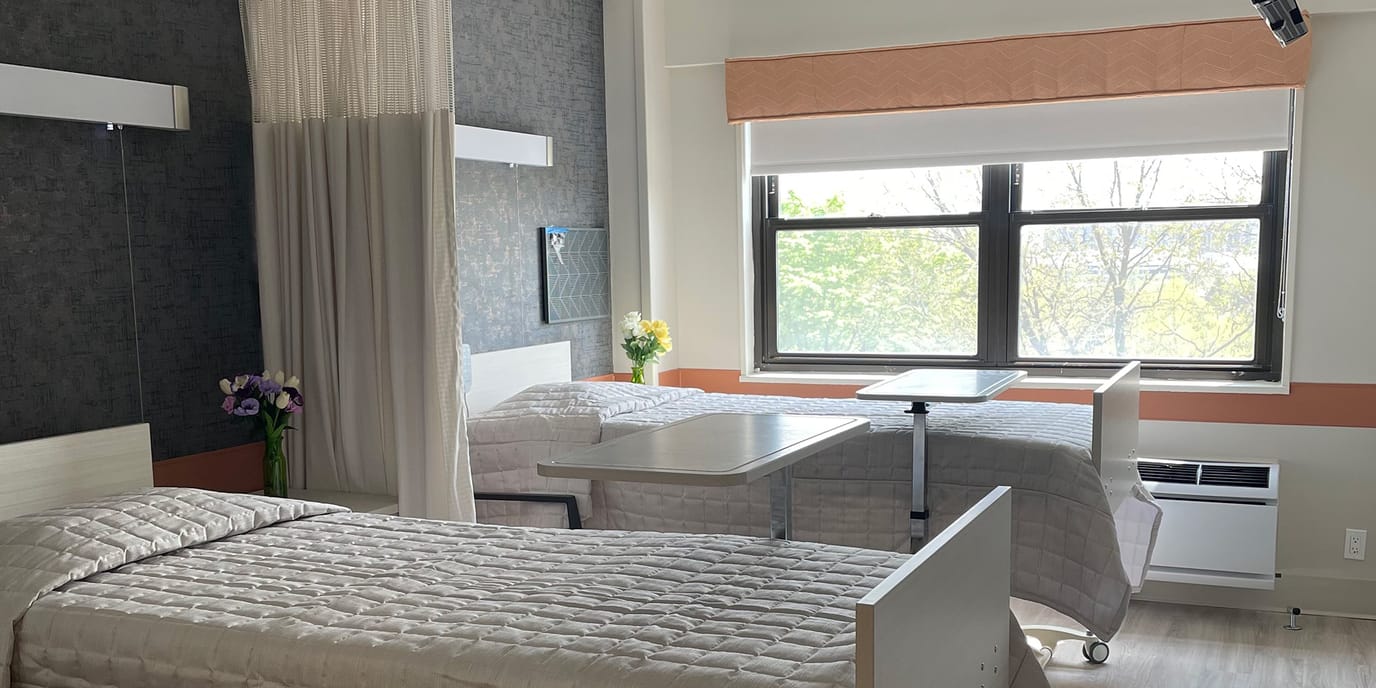 Private resident room with two beds and natural light