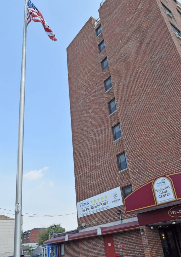 Exterior view of a senior living facility with flag