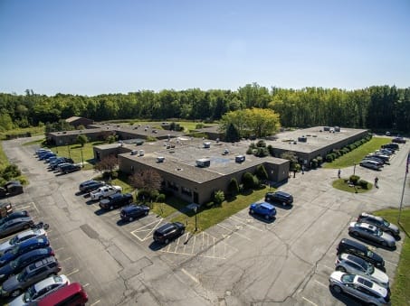 Aerial view of a senior living facility with parking and trees