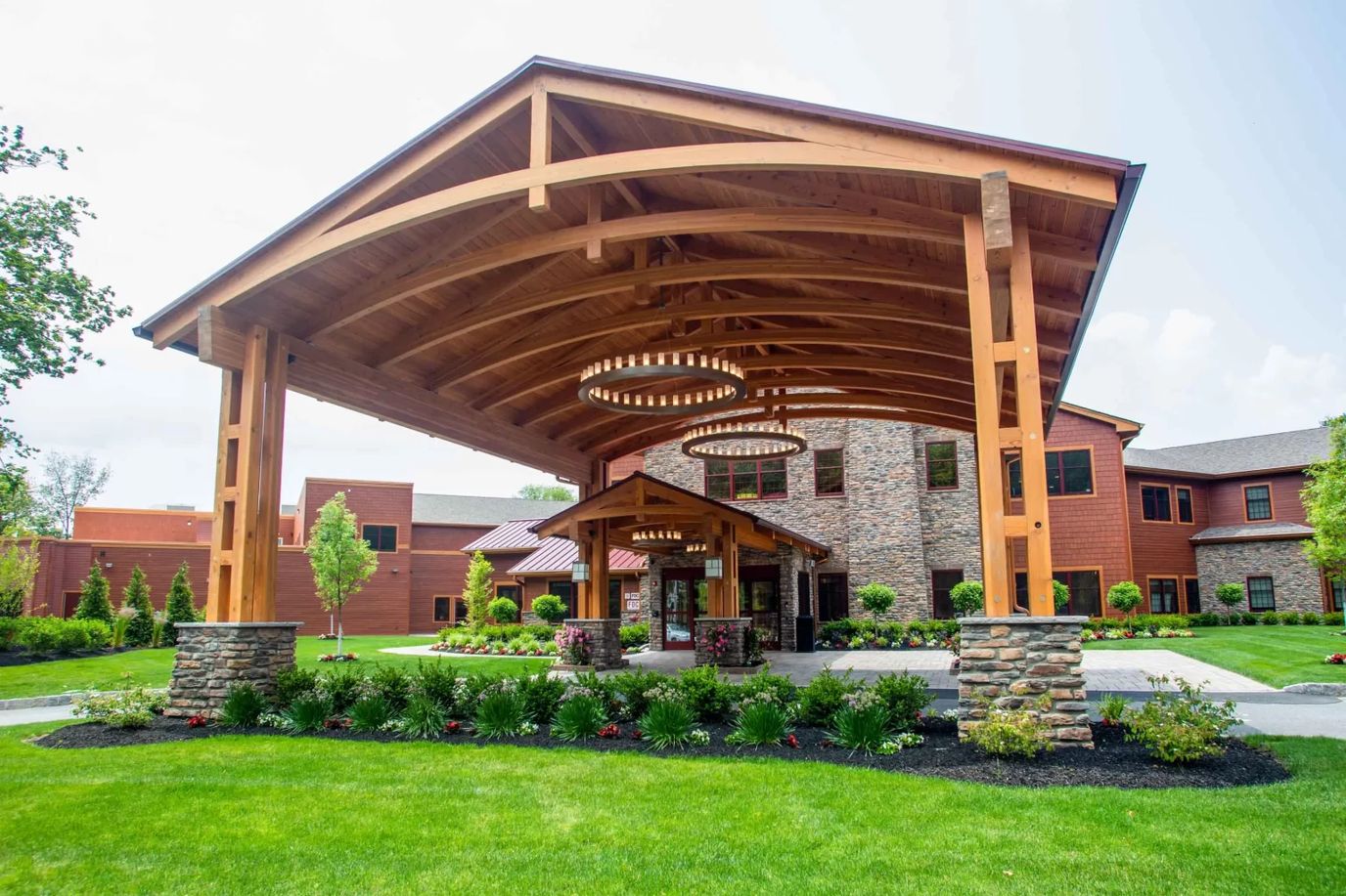 Covered entrance of a senior living facility with landscaping