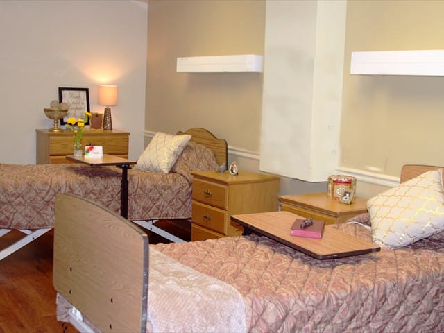 A private resident room with two beds and decor