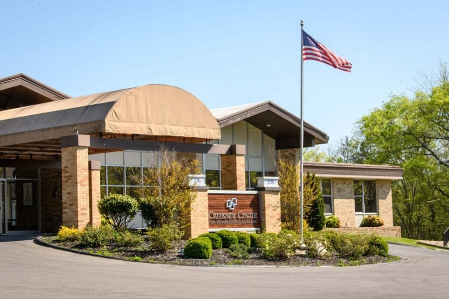 Front entrance of a senior care facility with flag