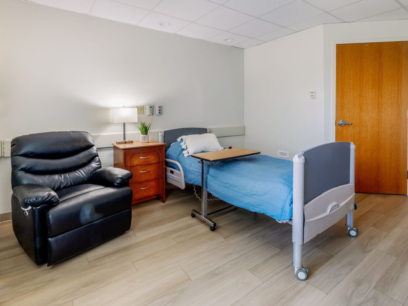 Cozy resident room with a bed and recliner chair
