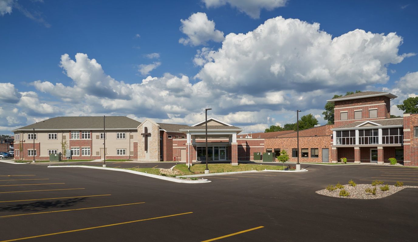 Front view of a senior living facility with parking