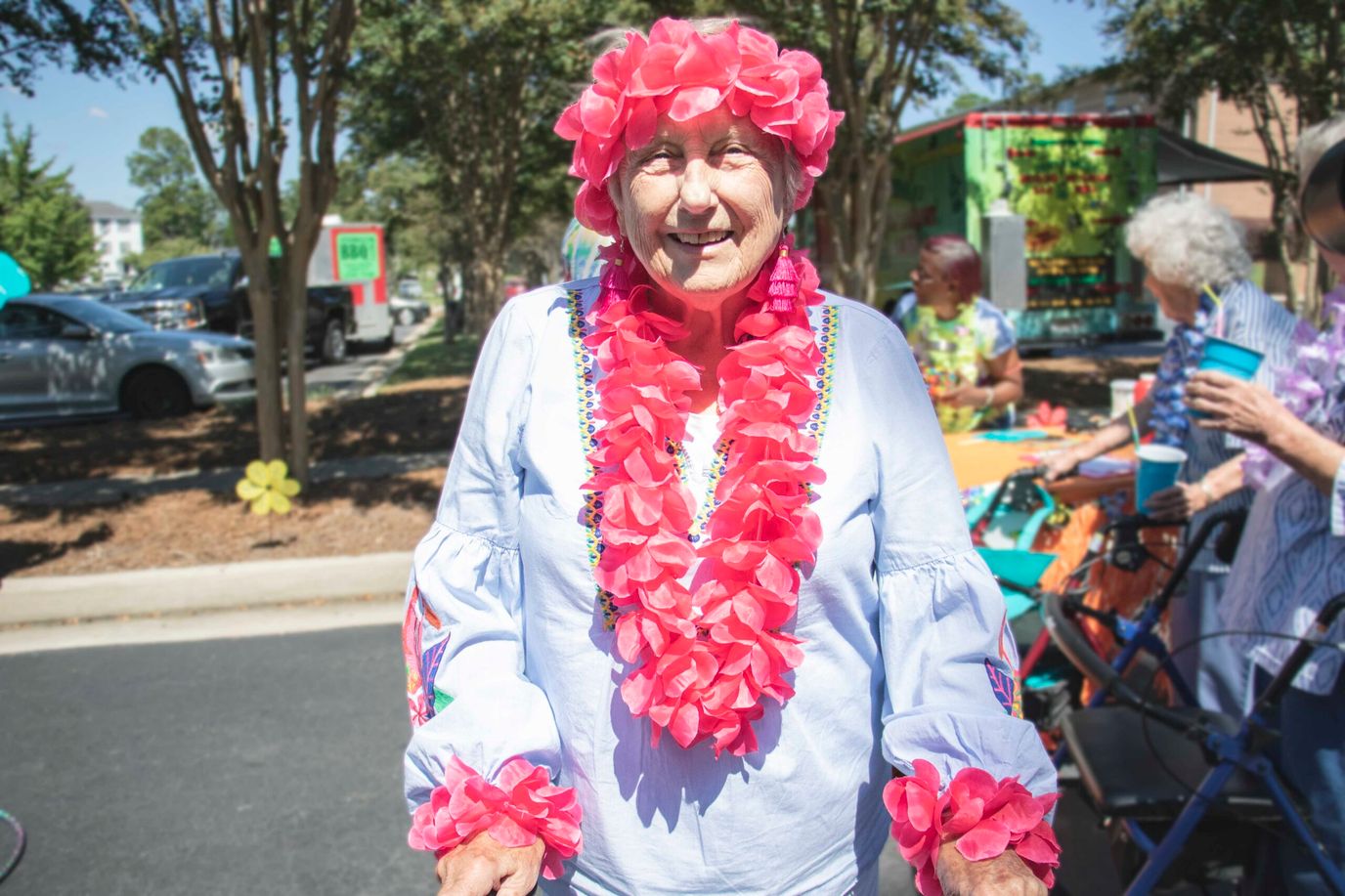 Magnolia Manor – Rock Hill, Nursing Home in Rock Hill, SC — Senior resident wearing a floral lei and smiling brightly