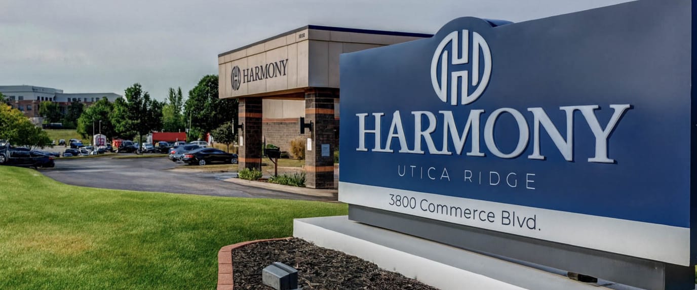 Facility entrance sign with logo and exterior view