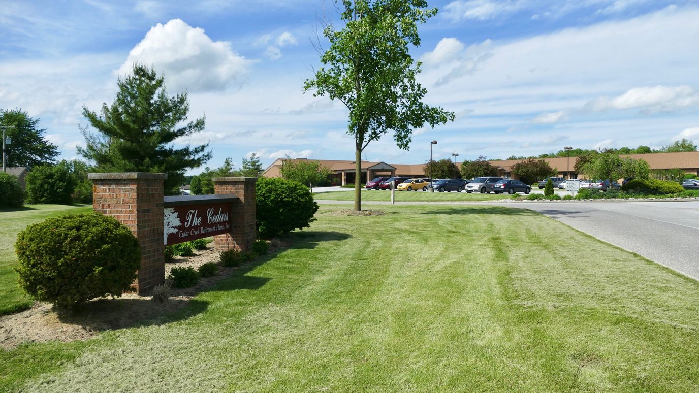 Exterior view of a senior living facility with landscaped lawn