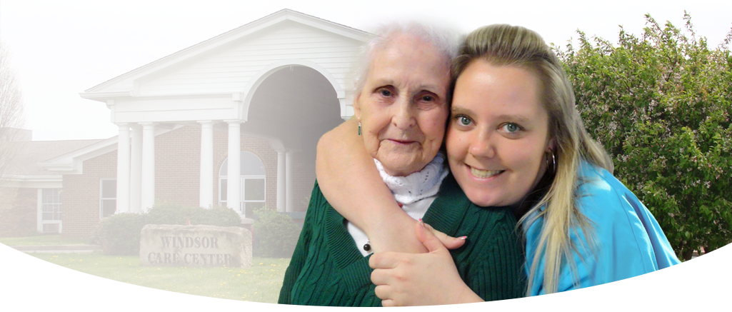Elderly woman and caregiver smiling in front of facility