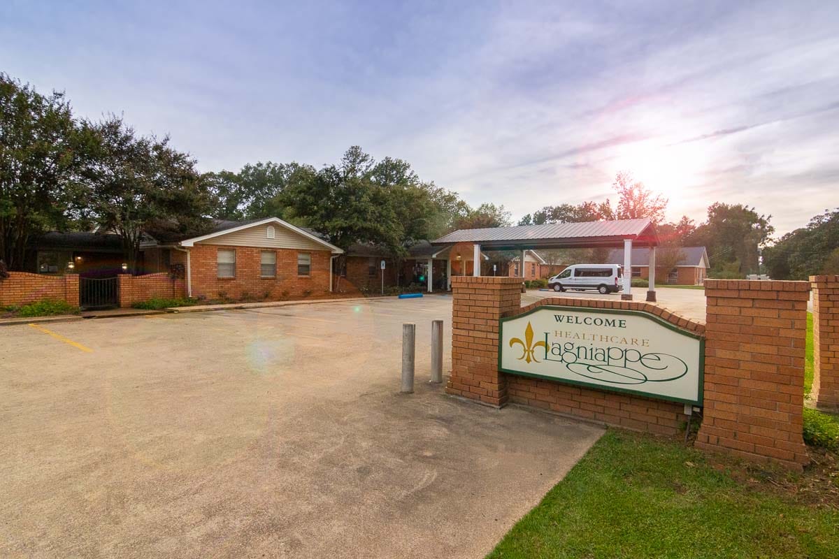 Exterior view of a senior care facility with a welcoming sign