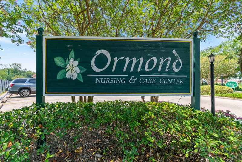 Signage of Ormond Nursing & Care Center surrounded by greenery