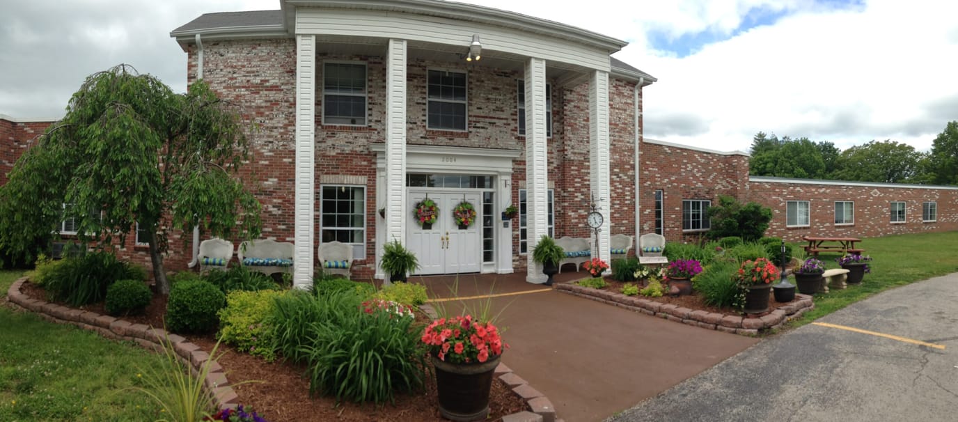 Front exterior of a senior living facility with gardens