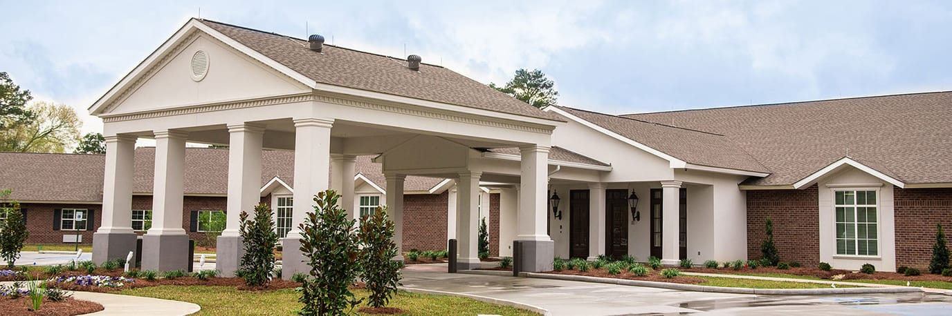 Front entrance of a senior living facility with landscaped pathway