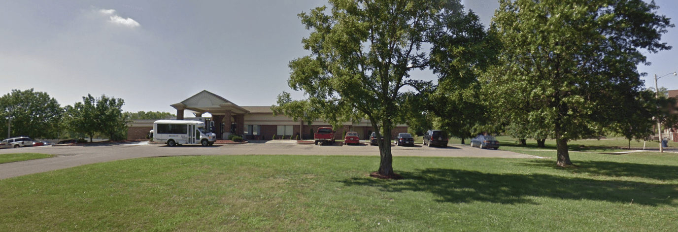 Exterior view of a senior living facility with parking