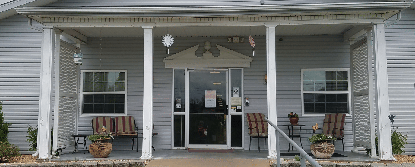 Front entrance of a senior living facility with outdoor seating