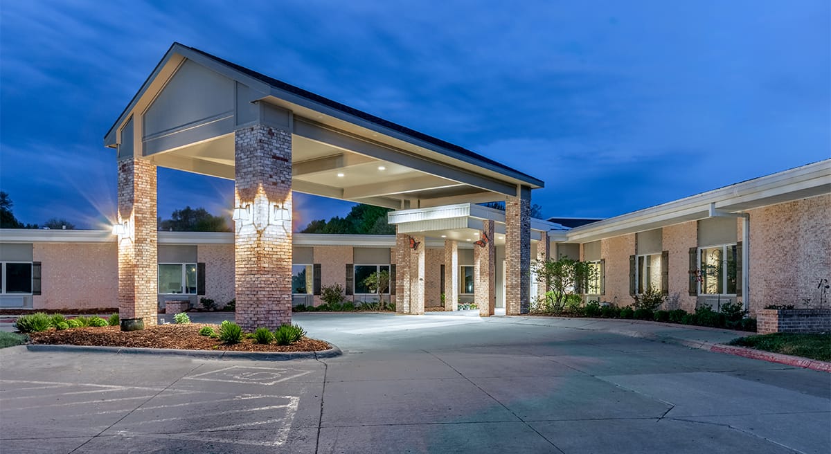 Brookestone of Papillion, Nursing Home in Papillion, NE — Entrance of a senior living facility at dusk