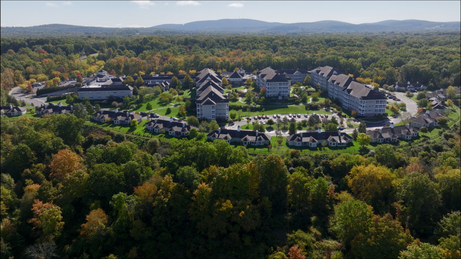 Aerial view of a large senior living campus with colorful trees