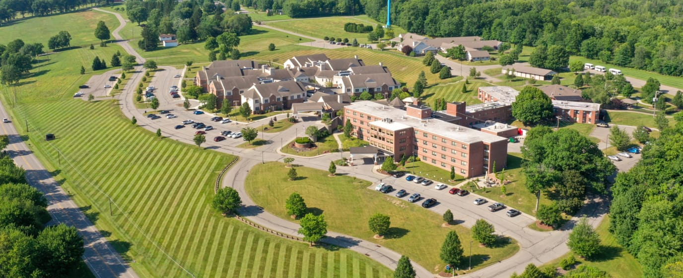 Aerial view of a large senior living facility with landscaped grounds