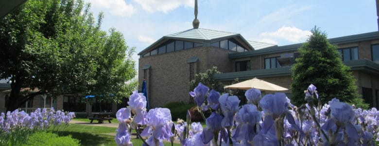 Exterior view of a senior care facility surrounded by flowers