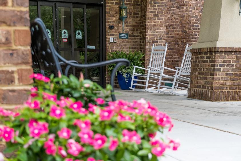 Welcoming patio area with rocking chairs and flowers