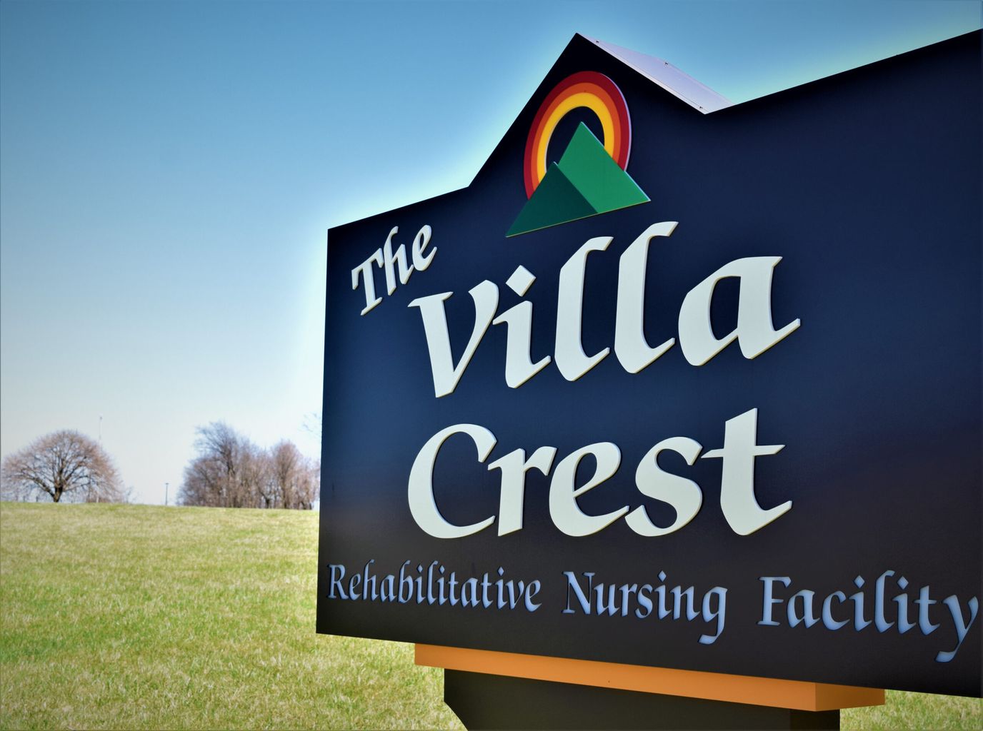 Sign for The Villa Crest nursing facility against blue sky