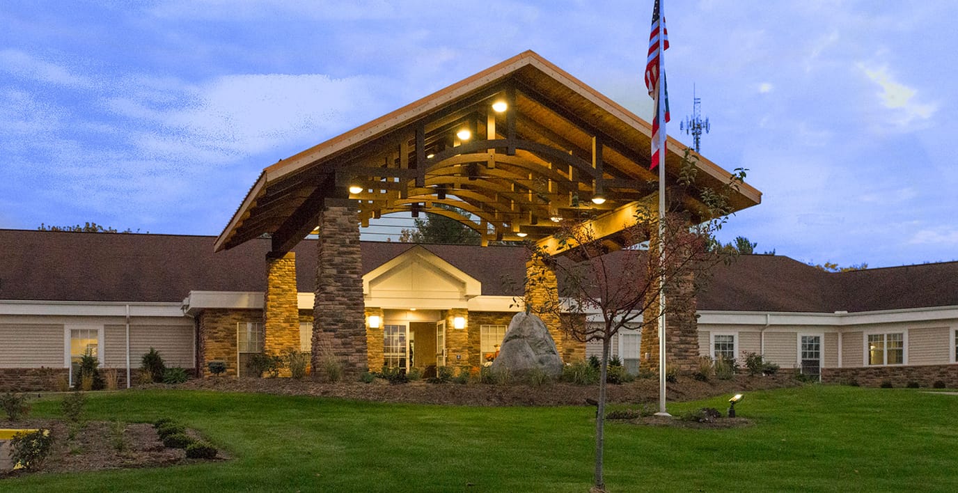 Exterior view of a senior living facility with a wooden entrance