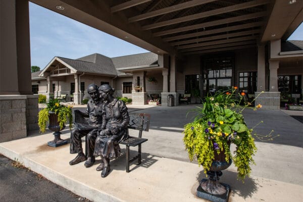 Statue of an elderly couple sitting outside the facility