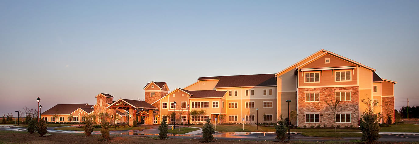 Exterior view of a senior living facility at sunset