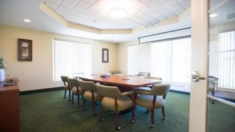 An interior conference room with a large table and chairs