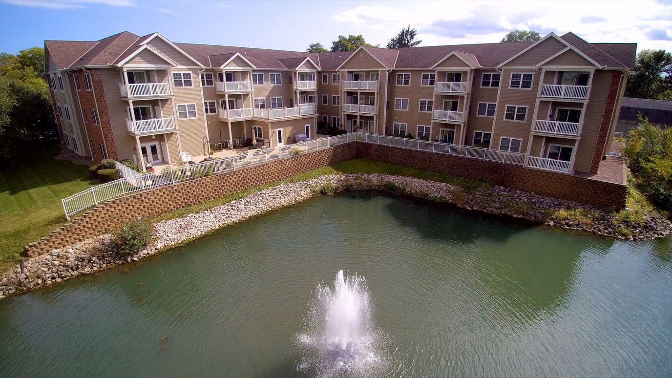 Exterior view of Willowbrook Place with a pond and fountain