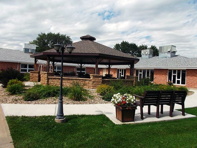 Outdoor gazebo area with garden flowers and benches