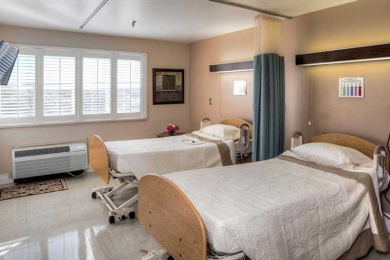 A shared resident room with two beds and natural light