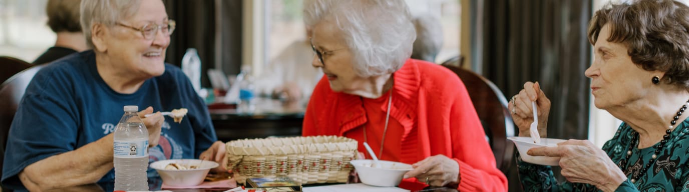 Three elderly women enjoying a meal together