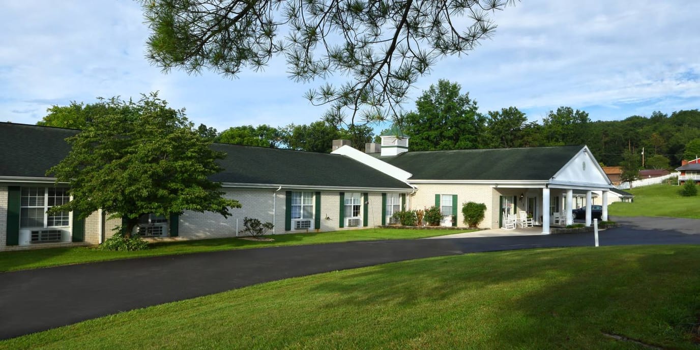 Exterior view of assisted living facility among greenery