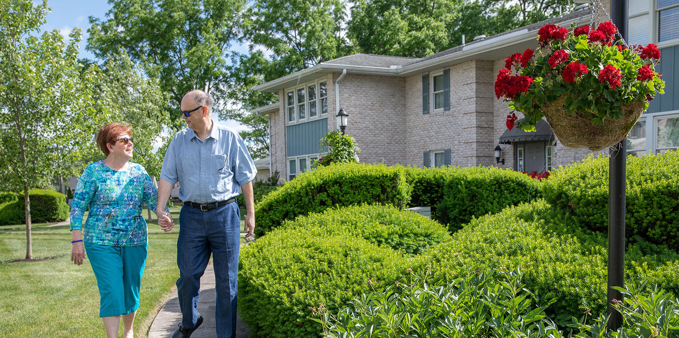 Residents walking in the garden area of the facility