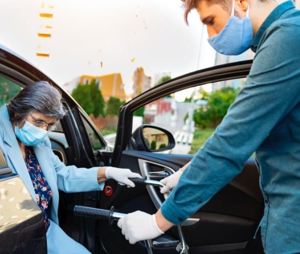 A caregiver assisting a resident entering a vehicle