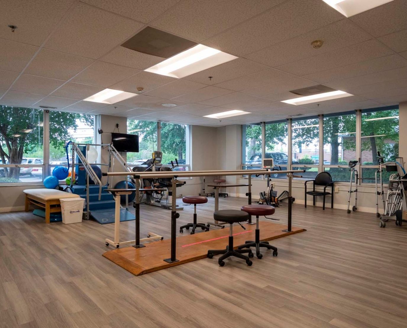 Rehabilitation therapy room with exercise equipment and windows
