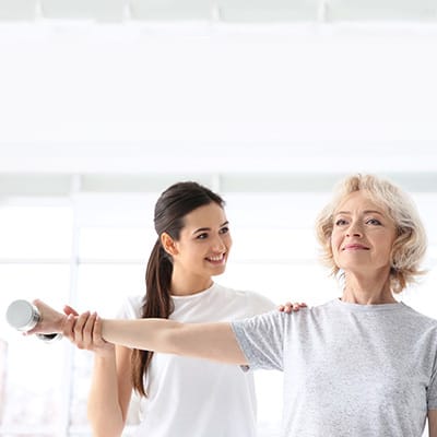 A caregiver assisting a senior with exercise