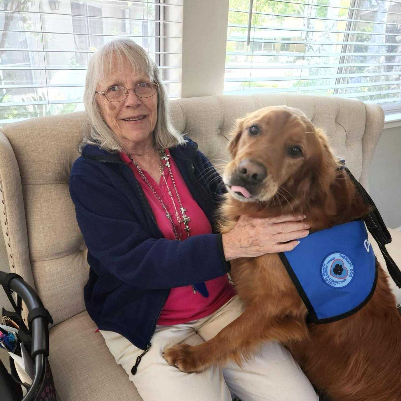 Resident enjoying time with a therapy dog in a lounge