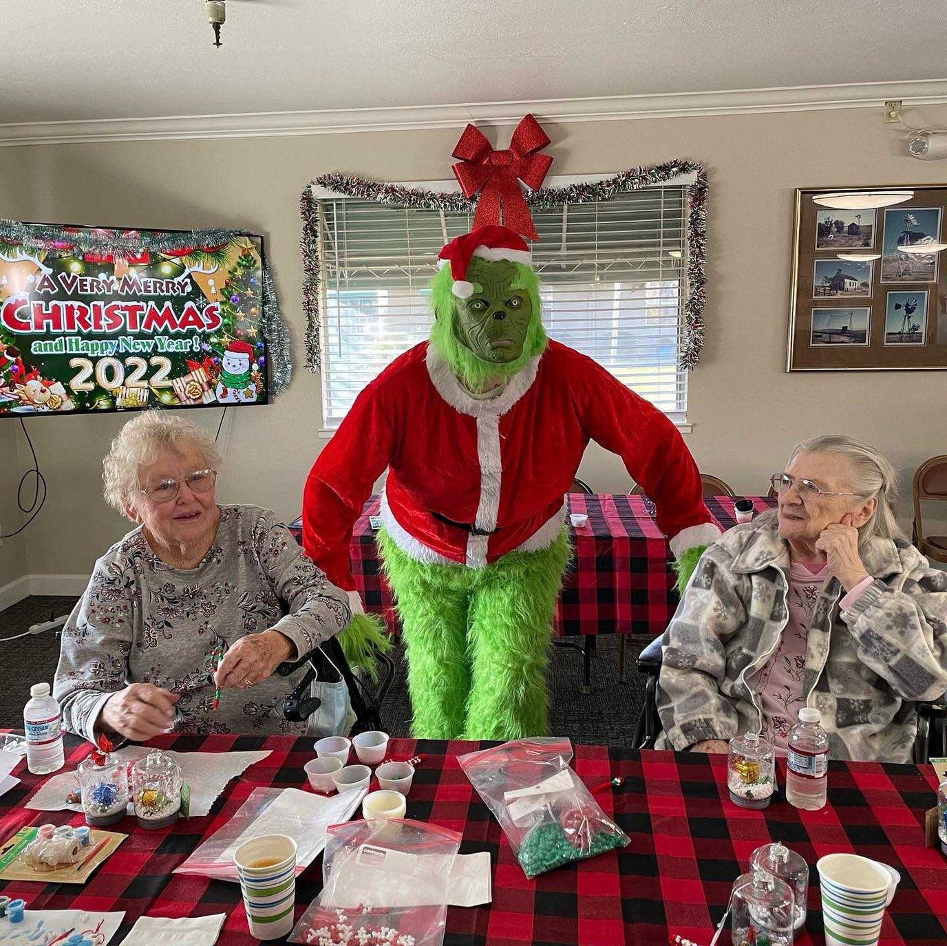 Residents with costumed character in a decorated room