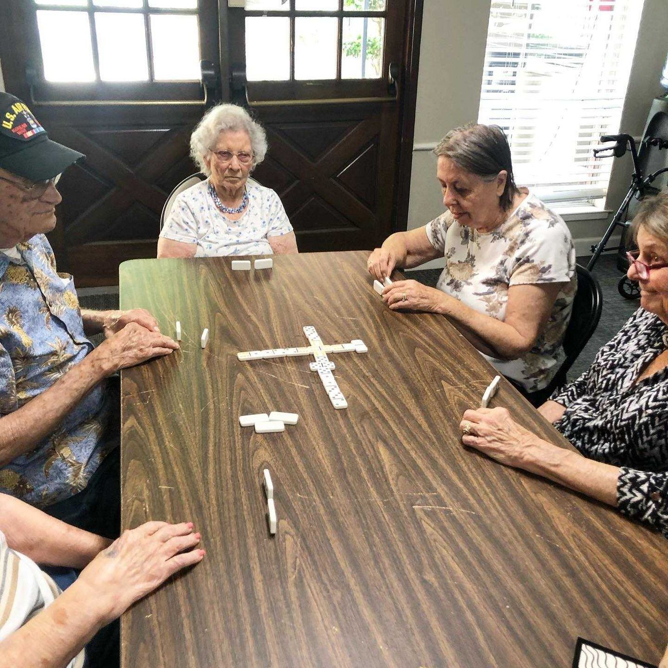 Residents playing dominoes around a table