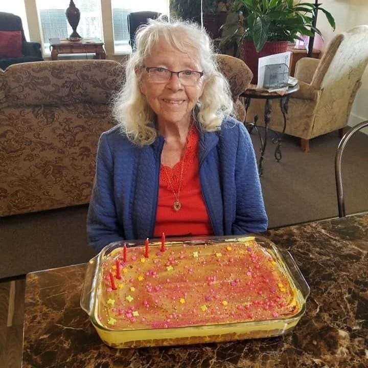 Resident celebrating with a decorated cake in the common area