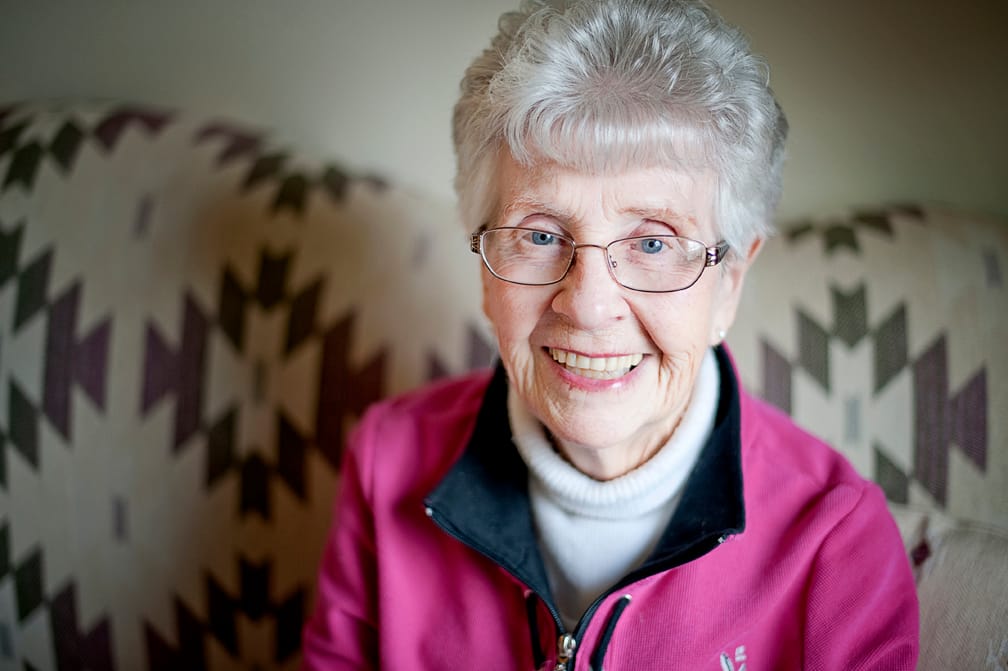 Elderly woman smiling in a cozy interior setting