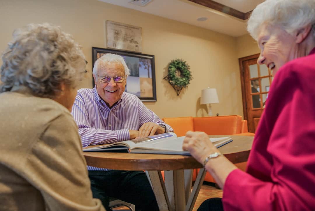 Residents engaged in conversation around a table