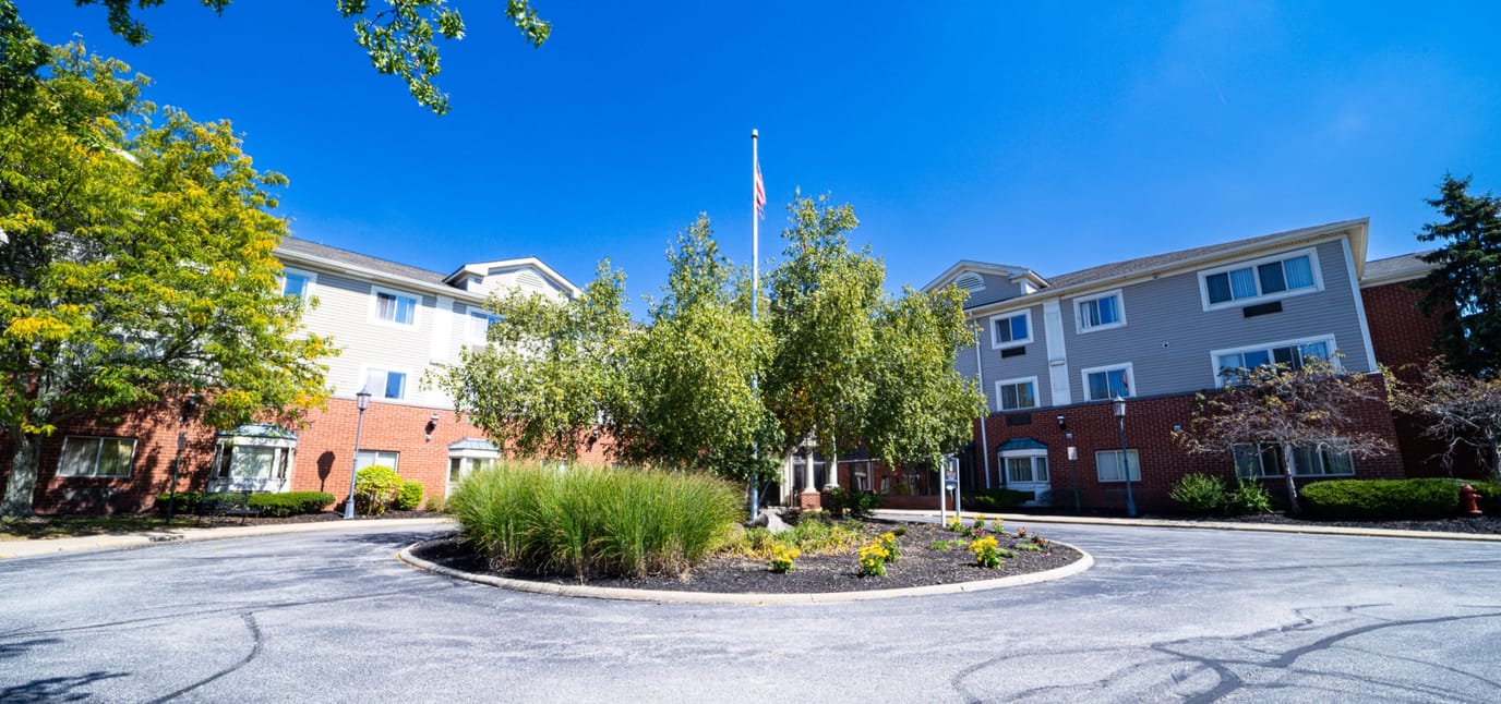 Exterior view of Heritage of Lyndhurst with trees and flag